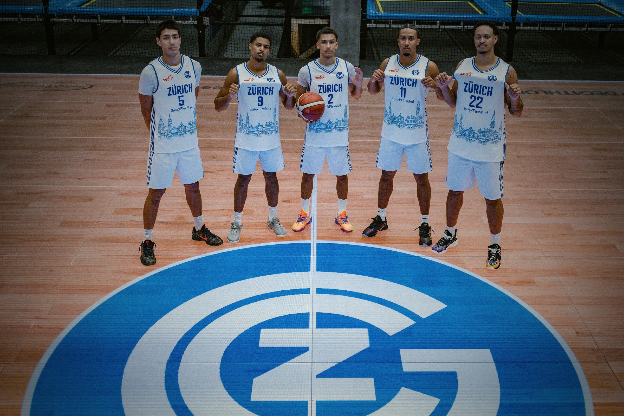 Fünf Spieler stehen nebeneinander auf dem GC-Logo am Mittelkreis