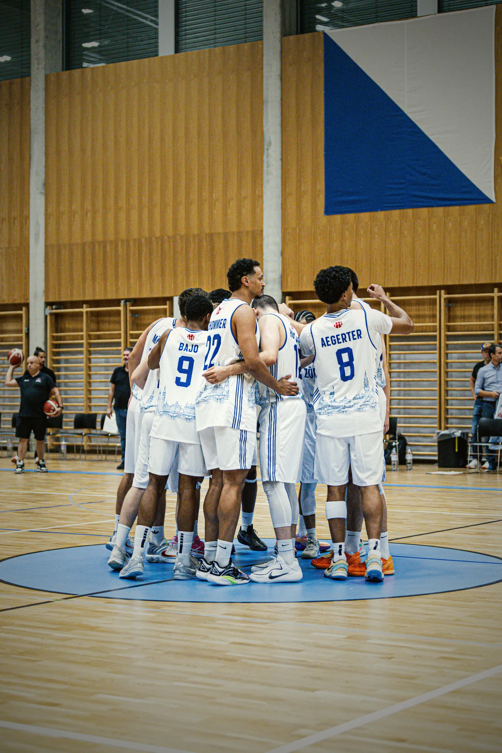 Das Team von GC Basketball im weissen Heimtrikot steht im Kreis zusammen