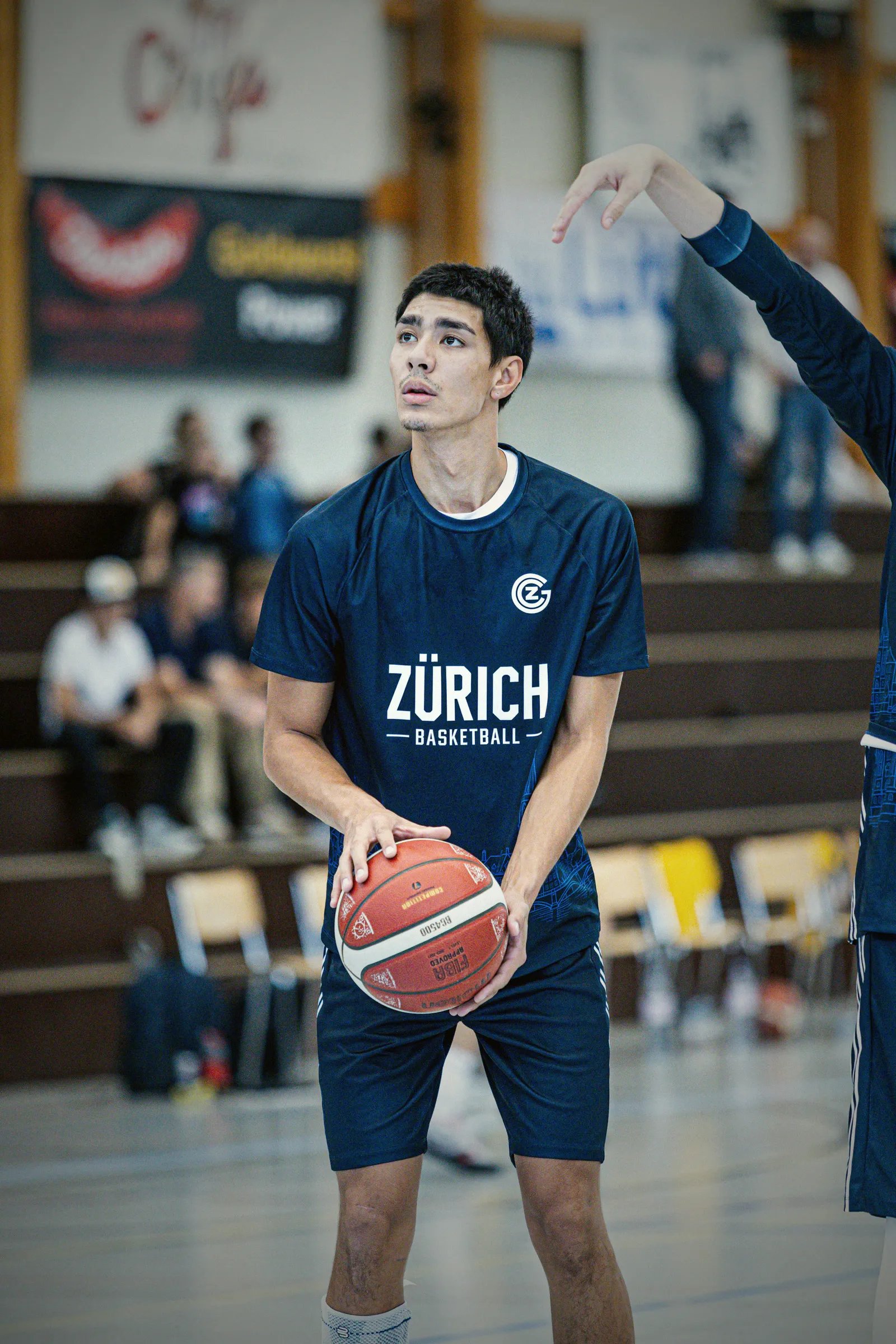 Spieler im dunkelblauen Warm-up Shirt mit Zürich-Schriftzug hält den Ball vor dem Spiel